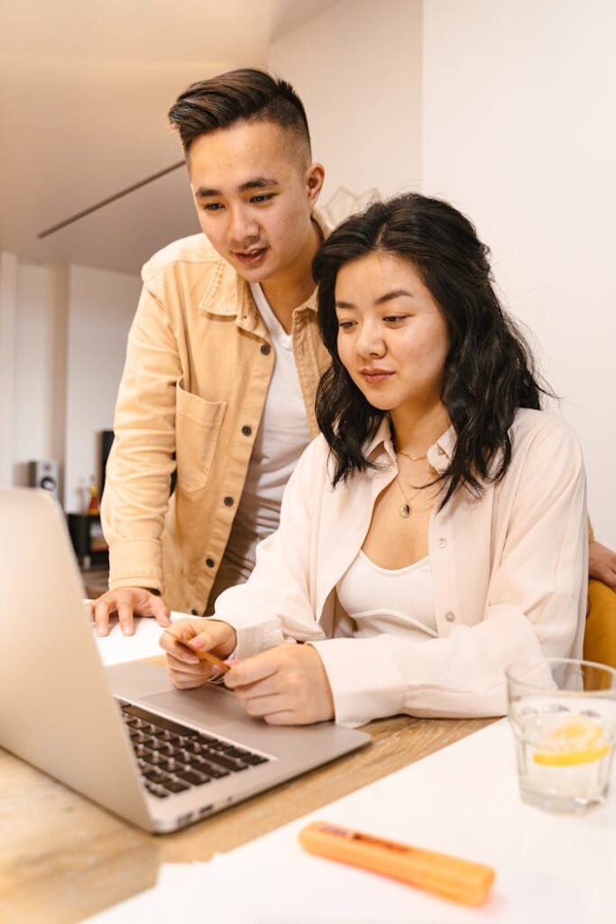 Woman and Man Using a Laptop Together